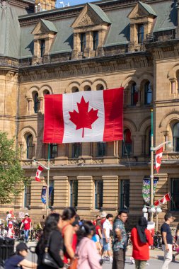 Kanada, Ottawa - 1 Temmuz 2024: Kanada Günü şehir merkezinde. Wellington caddesinde, Başbakan ve Danışma Meclisi binasının yakınındaki insanlar yürüyor. Kanada bayrağı