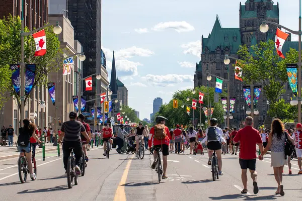 Kanada, Ottawa - 1 Temmuz 2024: Kanada Günü şehir merkezinde. Parlamento Tepesi yakınlarındaki caddede insanlar yürüyor ve bisiklete biniyor..