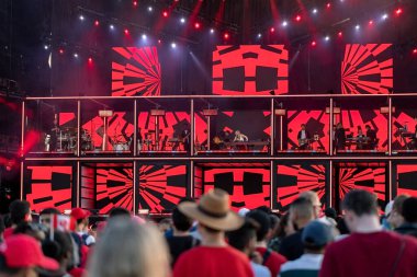 Ottawa, Ontario - 1 Temmuz 2024: Kanada Günü canlı performans. Kırmızı sahne ışıkları ve insanlar şovu izliyor..