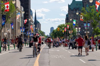 Kanada, Ottawa - 1 Temmuz 2024: Kanada Günü şehir merkezinde. Parlamento Tepesi yakınlarındaki caddede insanlar yürüyor ve bisiklete biniyor..