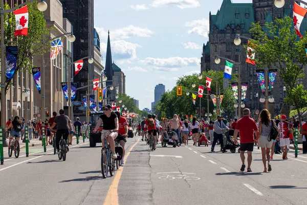 Kanada, Ottawa - 1 Temmuz 2024: Kanada Günü şehir merkezinde. Parlamento Tepesi yakınlarındaki caddede insanlar yürüyor ve bisiklete biniyor..