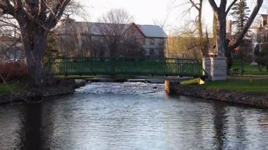 İlkbaharda bir derenin üzerindeki yaya köprüsü. Stewart Park Perth, Ontario, Kanada.