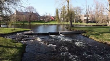 Güneşli bahar gününde deresi olan bir şehir parkı. Stewart Park Perth, Ontario, Kanada.