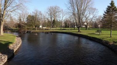 Stewart Park Perth, Ontario, Kanada. Güneşli bir bahar gününde küçük bir nehri olan şehir parkı.