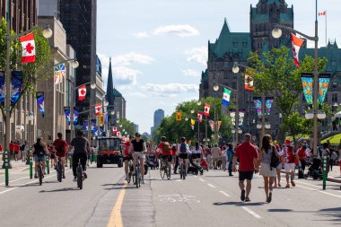 Kanada, Ottawa - 1 Temmuz 2024: Kanada Günü şehir merkezinde. Parliament Hill yakınlarındaki Wellington caddesinde insanlar yürüyor ve bisiklete biniyor..