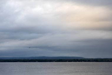 Gün batımında bulutlu gökyüzü ve nehir. Kanada 'da Ottawa Nehri