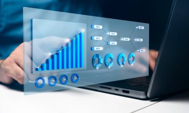 Etkileşimli grafikler ve çizelgeler içeren bir dizüstü bilgisayar üzerinde çalışan kişi. Resim veri analizini, performans ölçümlerini ve iş analizindeki teknolojiyi gösteriyor.