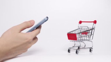 El, akıllı telefon kullanarak el arabası, küçük alışveriş arabası ve yüzen paketlerle sembolize edilir..