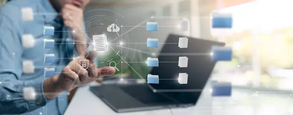 Dijital belgeleri yönetmek için dizüstü bilgisayar kullanan bir kişi, dijital çağda belge yönetimi ve organizasyon kavramını vurguluyor.