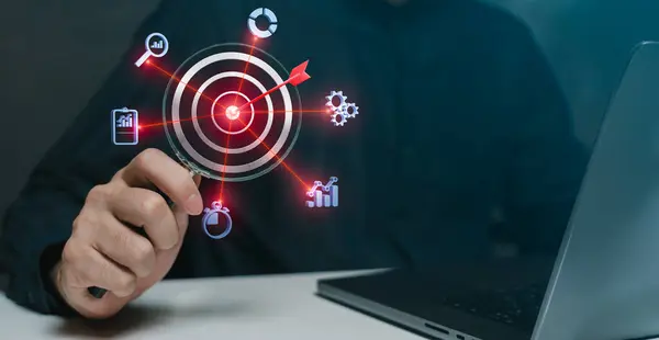 İş stratejisi, büyüme ve analitiği temsil eden ikonları olan dijital bir hedefe odaklanmak için büyüteç kullanan bir işadamı.