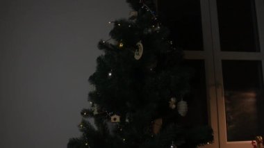 Noel ağacı mı? Noel ağacı süslemelerine yakın çekim. Noel ağacının ışıkları. Noel ve yeni yıl süslemeleri. Süslemeli, hediyeli ve şekerli Noel ağacı. Pencere kenarındaki dekorasyonlar.