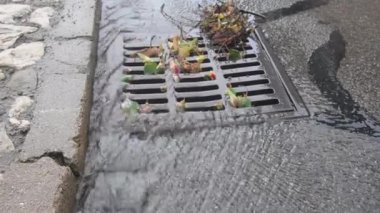 Su rögar kapağından akıyor. Yağmur bir kanalizasyon sistemine akar. Şiddetli bir yağmurdan sonra su kanalizasyona akar..