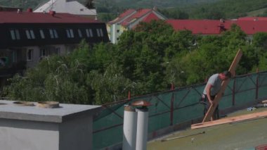 Binanın etrafındaki iskeleye. İskelenin yukarısından POV. Eski binanın yeniden inşası. Roofer tahtaları ahşap bir çatıya dizer. Termal yalıtım yerleştiriliyor..