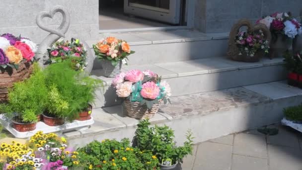 フラワーショップの外に花のアレンジメントと花束 花屋の前で販売する準備ができて花 植物や花を持つ花の店の外観 花と家の装飾 — ストック動画