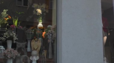 Çiçekçi dükkanının önünde satışta olan çiçekler. Kaldırımda çiçek askıları var. Çiftçilerin bitkilerini satmak. Çiçeklerden para kazanmak. Fabrika satarak para kazanıyordum. Küçük işletme kuruluşu.