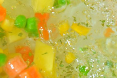 Yakın plan taze sebzeler havuç, bezelye, karnabahar, mısır doğranmış patates ve su zemininde maydanoz. Havuçlu sebze, bezelye, karnabahar, mısır, doğranmış patates ve...