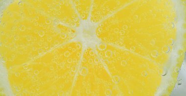 Köpüklü taze limon dilimi. Limonlu soda dilimine yakın çekim. Limonlu baloncuk. Karbonatlı suya bir dilim limon..