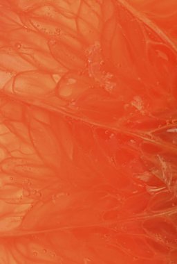 Grapefruit close-up. Slice of blood red ripe grapefruit. Texture of red juicy grapefruit. Macro vertical image. 