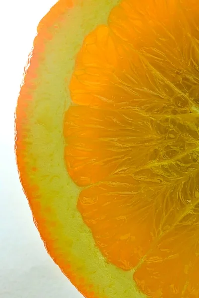 Close-up of fresh orange slice on white background. Slice of orange  in sparkling water on white background, close-up. Horizontal image.ice in liquid with bubbles. Slice of orange fruit in water. Close-up of fresh orange fruit slice covered by bubble