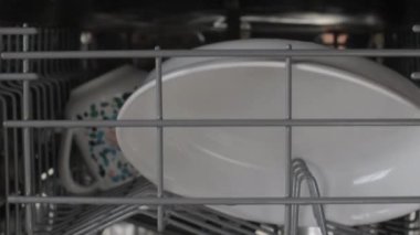House chores concept. Hand opening dishwasher door. Male hand opens the dishwasher machine. Zoom in motion. Close-up.