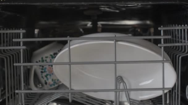 年轻人打开洗碗机的门 在白色厨房里打开有干净盘子的洗碗机 放大移动速度 4K镜头 — 图库视频影像