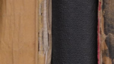 Passing row of antique vintage books. Book shelfs in library. Close- up. Many books organized in shelves in a big bookstore.