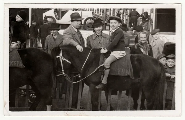 チェコスロバキア社会主義共和国 1950 年代頃 ヴィンテージ写真ショー家族遊園地で 馬に小さな男の子が座っています — ストック写真
