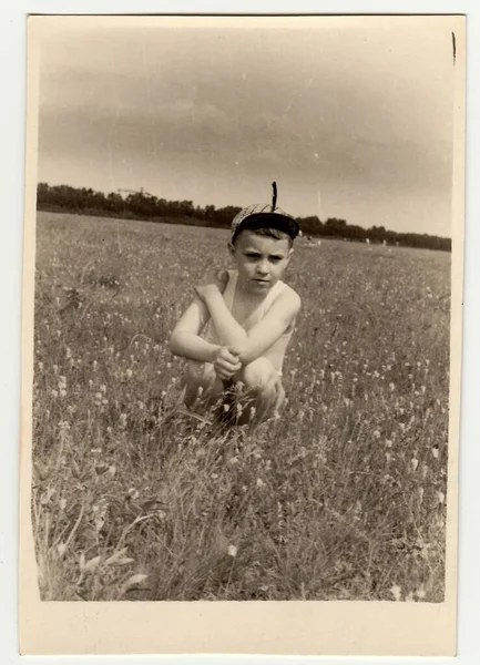 大约在 老式照片显示男孩坐在草地上 — 图库照片