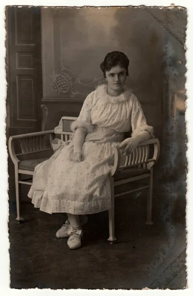 ドイツ Circa 1920 ヴィンテージ写真は 女性が白い期間のベンチに座って示しています レトロな黒と白のスタジオ写真 — ストック写真