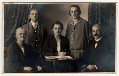 HEJNICE - HEINDORF, The CZECHOSLOVAK REPUBLIC - CIRCA 1930 'lar: Klasik fotoğraf aile pozlarını bir fotoğraf stüdyosunda gösteriyor. Sepya efektli siyah beyaz stüdyo fotoğrafçılığı.