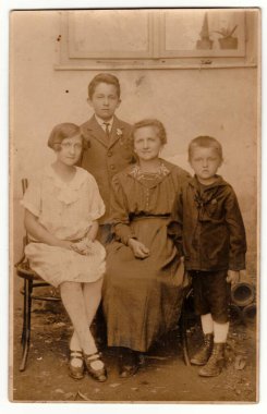 The CZECHOSLOVAK REPUBLIC - CIRCA 1920 'ler: Klasik fotoğraf motter ve çocuklarının dışarıda poz verdiğini gösteriyor. Sepya efektli siyah ve beyaz geçmişe dönük fotoğraf.