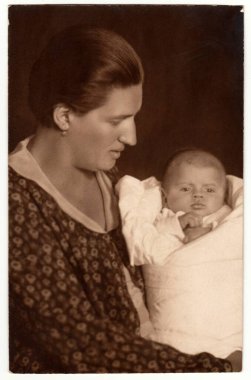 The CZECHOSLOVAK REPUBLIC - CIRCA 1930 'lar: Klasik fotoğraf kundağa sarılmış bebekli bir kadını gösteriyor. Retro siyah beyaz stüdyo fotoğrafçılığı.
