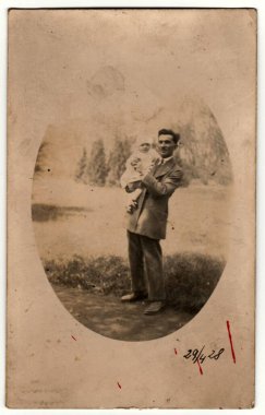 PRAHA (PRAGA), The CZECHOSLOVAK REPUBLIC - 29 Nisan 1928: Vintage foto show man beşikte küçük bir bebek. Retro siyah beyaz fotoğraf. Çember 1930 'lar.