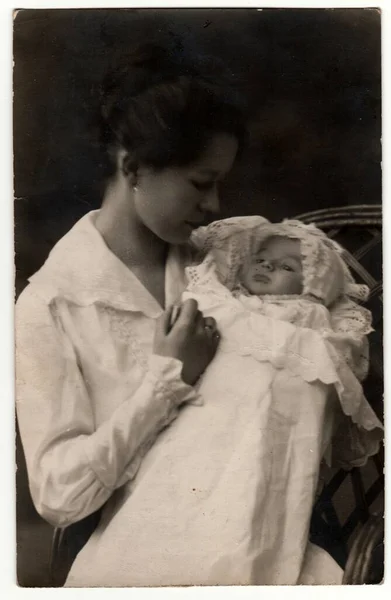 ドイツ エイプリル社1918年25日 ビンテージ写真は スワッドリング服を着た新生児を持つ女性を示しています レトロな黒と白のスタジオ写真 — ストック写真