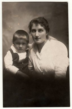 CZECHOSLOVAK REPUBLIC - CIRCA 1920 'ler: Klasik fotoğraf annesi olan küçük bir çocuğu gösteriyor. Retro siyah beyaz stüdyo fotoğrafçılığı. Yaklaşık 1920 'lerde..