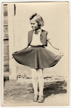 CZECHOSLOVAK REPUBLIC - CIRCA 1940 'lar: Klasik fotoğraf açık havada genç bir kızı gösteriyor. O, gururla eteğini gösterir. Retro siyah beyaz fotoğraf. 1940 'larda..