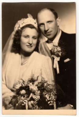 ZLIN, CZECHOSLOVAK REPUBLIC - 17 Mart 1944: Vintage fotoğraf yeni evlilerin düğün sonrası poz verdiğini gösteriyor. Retro siyah beyaz stüdyo fotoğrafçılığı. 1940 'larda..