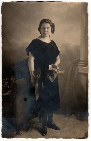 ドイツ Circa 1920 ヴィンテージ写真は 短い髪の女性を示しています 女性は黒いドレスを着て花束を持っています たくさんの花 セピア効果を持つレトロな黒と白のスタジオ撮影 1920年頃 — ストック写真