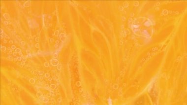 Gazlı suyla portakal diliminin makro görüntüsü. Karbonatlı sudaki portakal dilimine yakın plan.