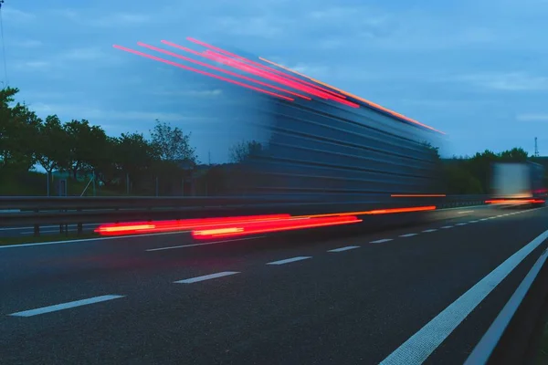 黄昏时 一辆卡车在高速公路上行驶 公路上的运动模糊了 卡车的夜间拍摄 国际运输和物流的概念 — 图库照片