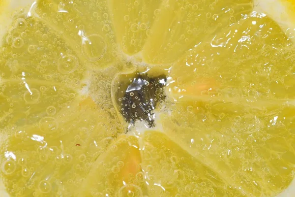 Close Dari Irisan Lemon Dalam Cairan Dengan Gelembung Potongan Lemon — Stok Foto