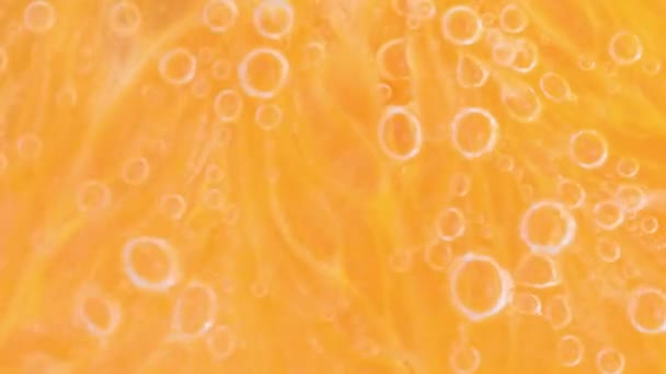 水の泡で熟したオレンジのスライス 輝く水の中でオレンジのスライスのマクロショット 炭酸水のオレンジのスライスのクローズアップ — ストック動画