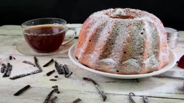 Eski ahşap arka plan üzerinde siyah çay ve adet vanilya kupa ile kum pasta moda. Rustik beyaz zemin üzerine stawberries ile yumurta sarısı sünger kek.