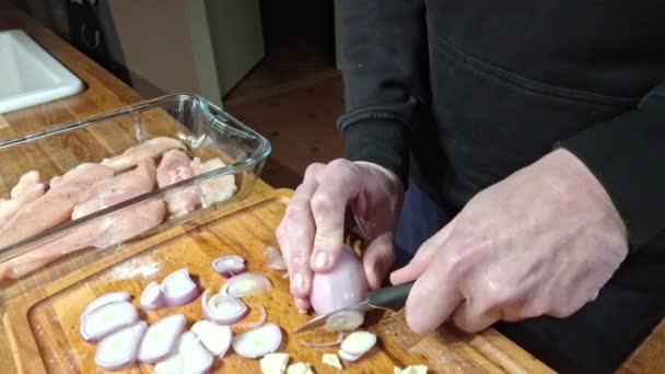 洋葱片把洋葱削成环状 一个人在木板上切剥皮的洋葱 准备鸡排在厨房烤箱里烘烤 烹调和烹调的概念 — 图库视频影像