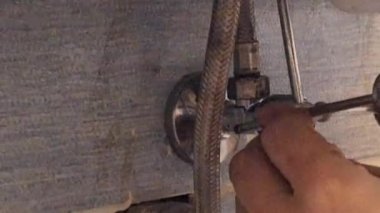 Tesisatçı fişten lavaboya kadar çekme çubuğunu tamir eder. Adamın biri lavabonun altındaki tesisatı tamir ediyor. Bakım, el işi, inşaat kavramı.