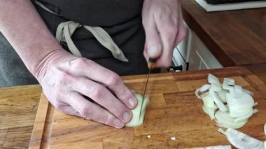 Aşçı soğanı dilimler. Erkek elleri soğanları dilimlere ayırıyor. Yemek pişirme, gastronomi ve aşçılık kavramı. Ev mutfağından görüntüler.