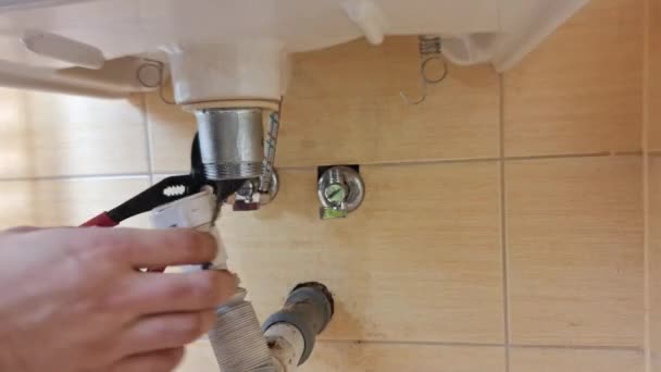 プランバーは バスルームのシンクから排水パイプを取り除きます 配管手は洗面台から廃棄物を分解する 家庭の小さな修理 Diy 工芸品 建設の概念 — ストック動画