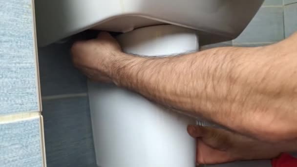 Ένας Υδραυλικός Εγκαθιστά Μισή Στήλη Κάτω Από Ένα Νεροχύτη Μπάνιου — Αρχείο Βίντεο