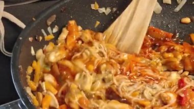 Şef et ve sebzeleri WOK tavasında karıştırır. Erkek elleri WOK kızartma tavasında sebze ve et karışımını karıştırır. Gastronomi, aşçılık, ev yemeği kavramı..