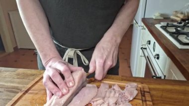 Şef tavuğu pirzola ve erişte olarak keser. Bir adamın elleri tavuğu pirzola ve sopa gibi keser. Gastronomi, aşçılık, ev yemeği kavramı. Bir adam yemek yapıyor..